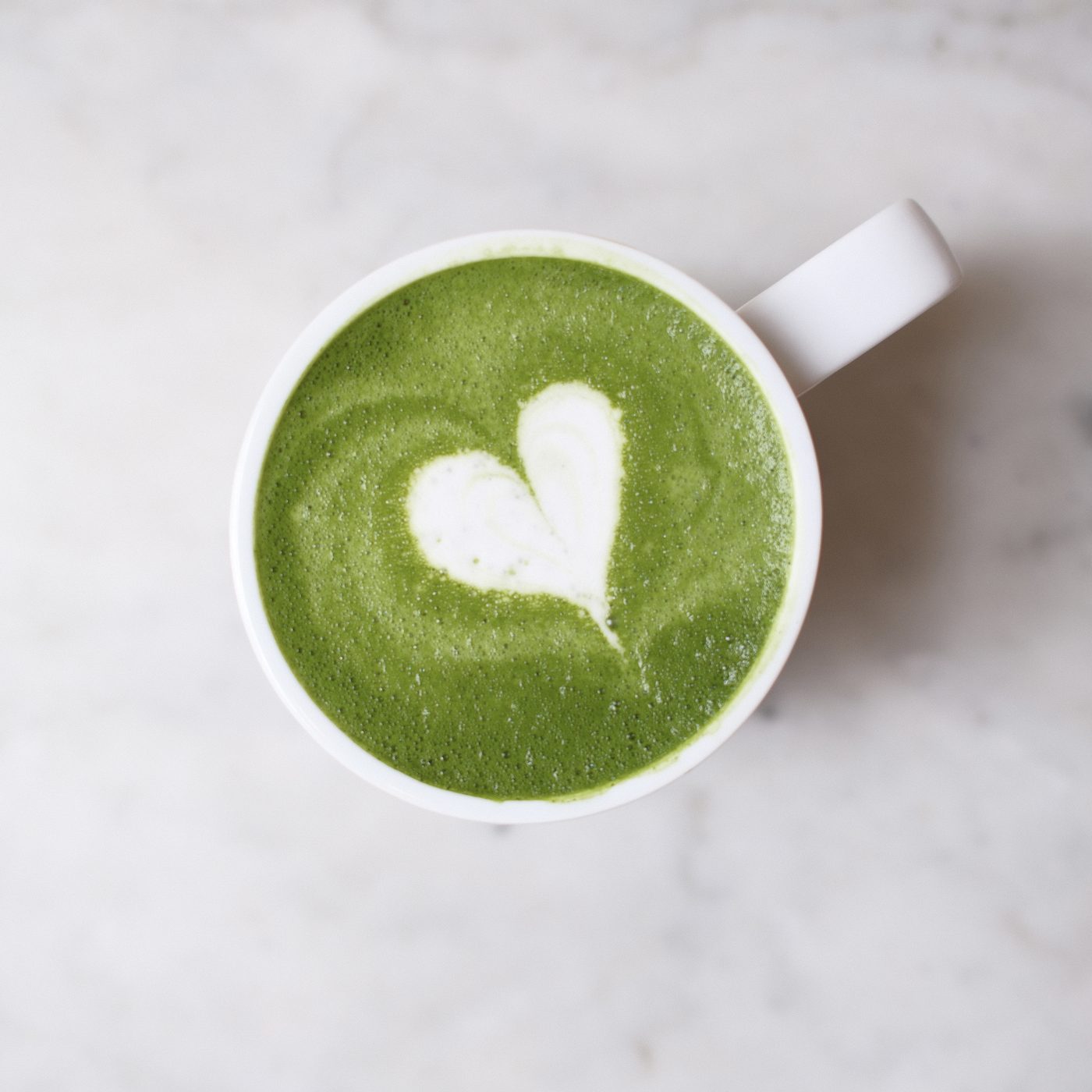 Matcha latte with a heart poured in the foam
