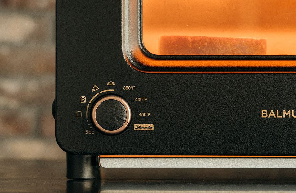 Bread toasting behind the lit window of BALMUDA The Toaster Pro