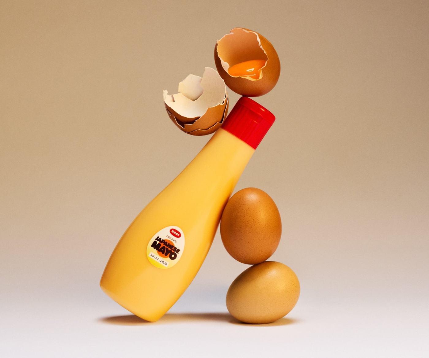 A CABI Original Japanese Mayo bottle balanced on brown eggs, a yolk dropping from a cracked shell