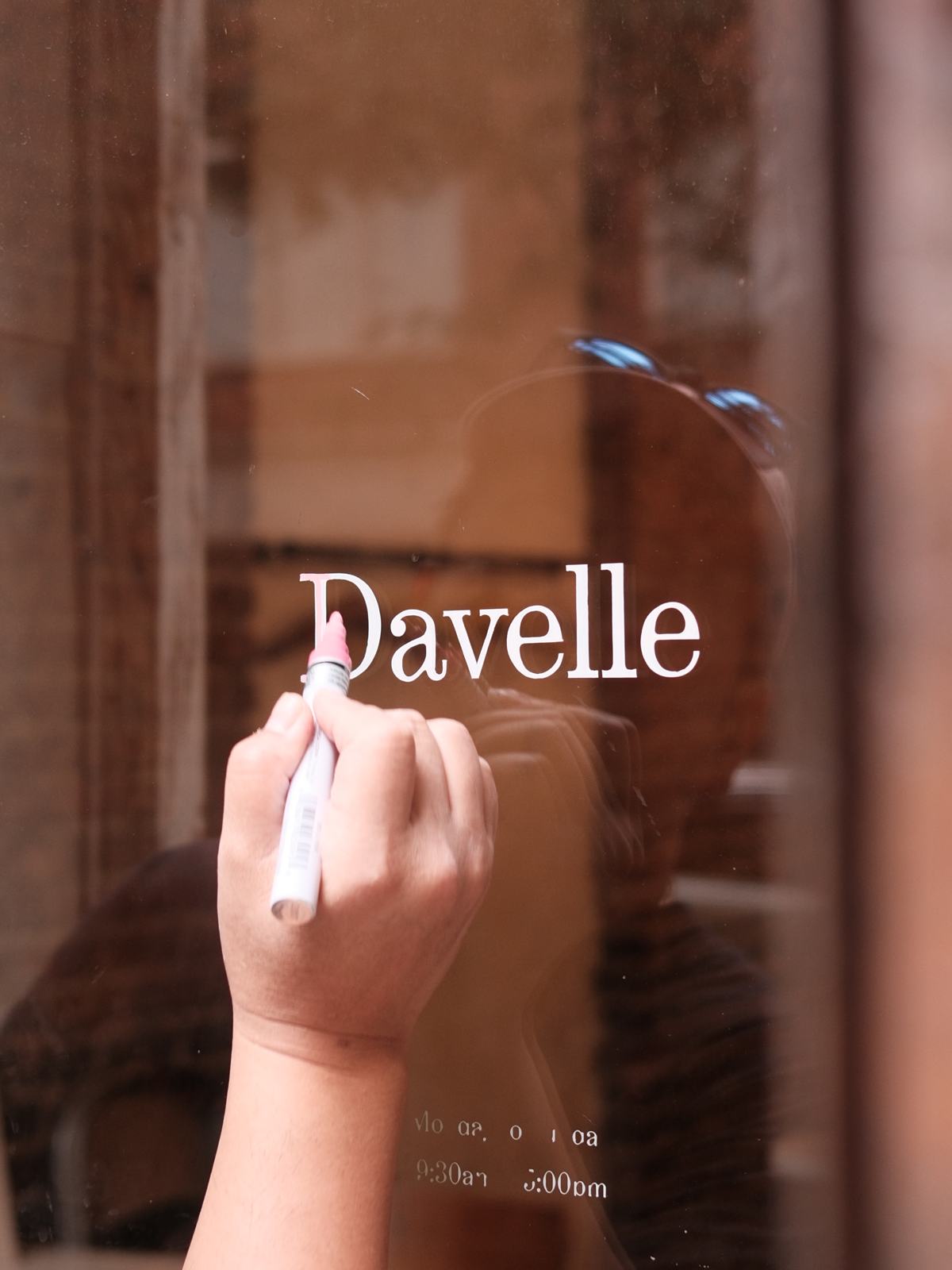 Davelle being hand-lettered on the window at 102 Suffolk Street