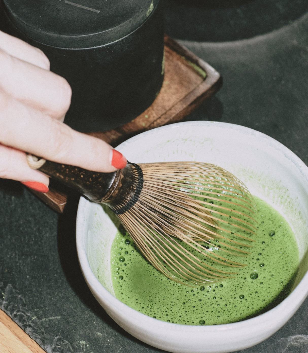 Whisking MAKE matcha to a foam with a bamboo whisk