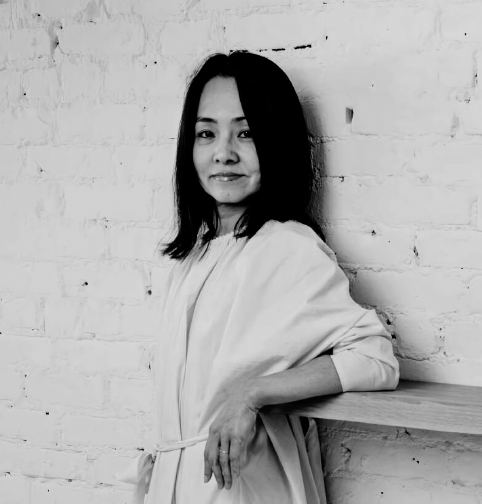 Kiyomi Tanigawa, founder of MISOMARU, leaning against a white brick wall