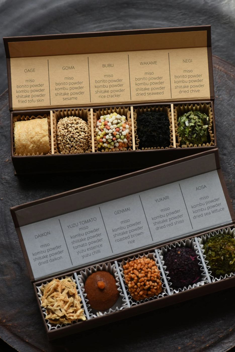Traditional and vegan MISOMARU boxes open, each ball labelled with its ingredients
